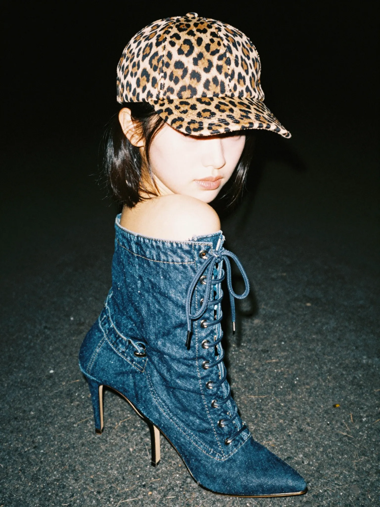 Authentic Y2K street fashion photography with harsh flash, leopard print cap, and denim lace-up stiletto boots.